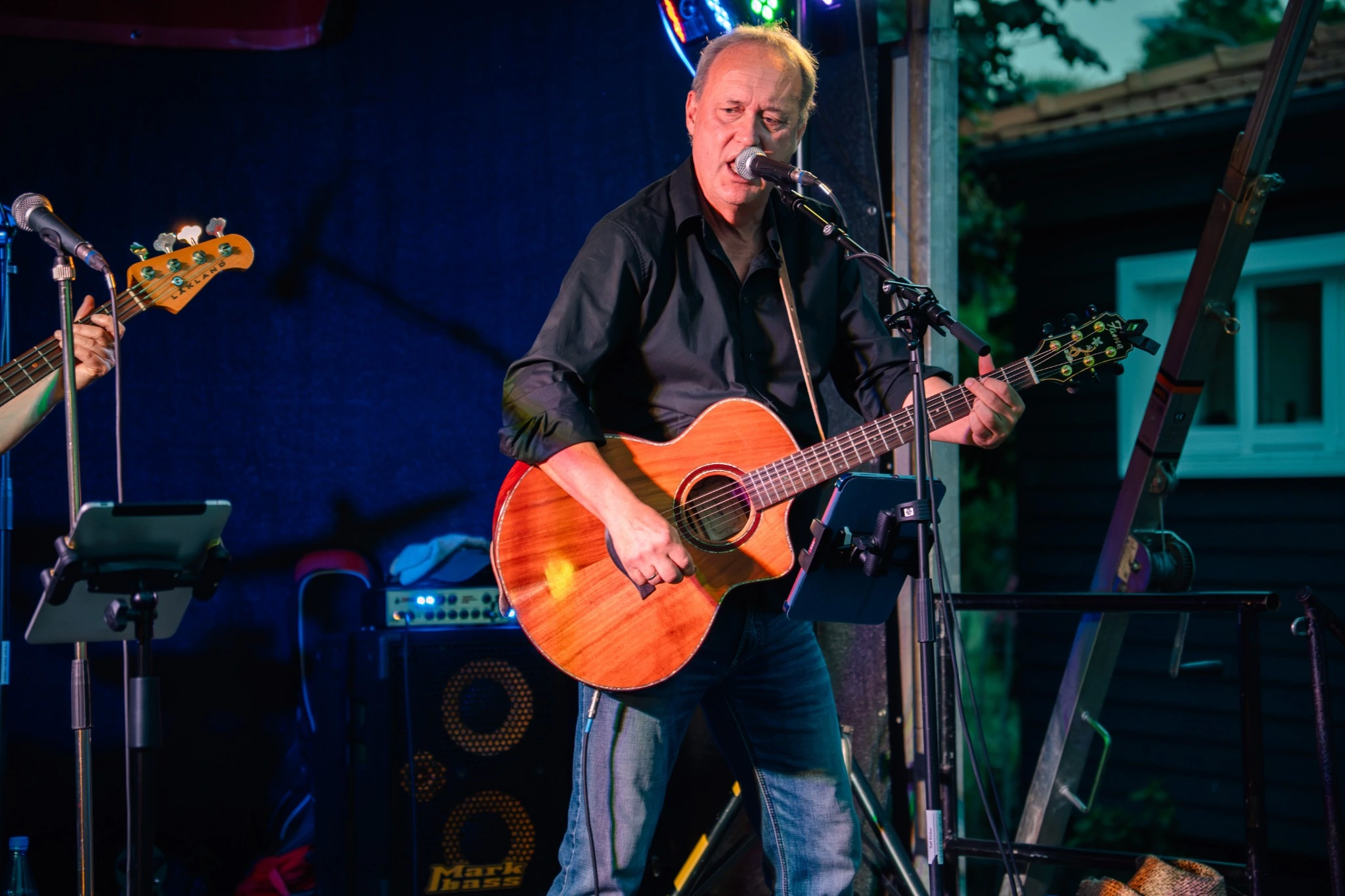 Peter Ernst singing and playing acoustic guitar on stage