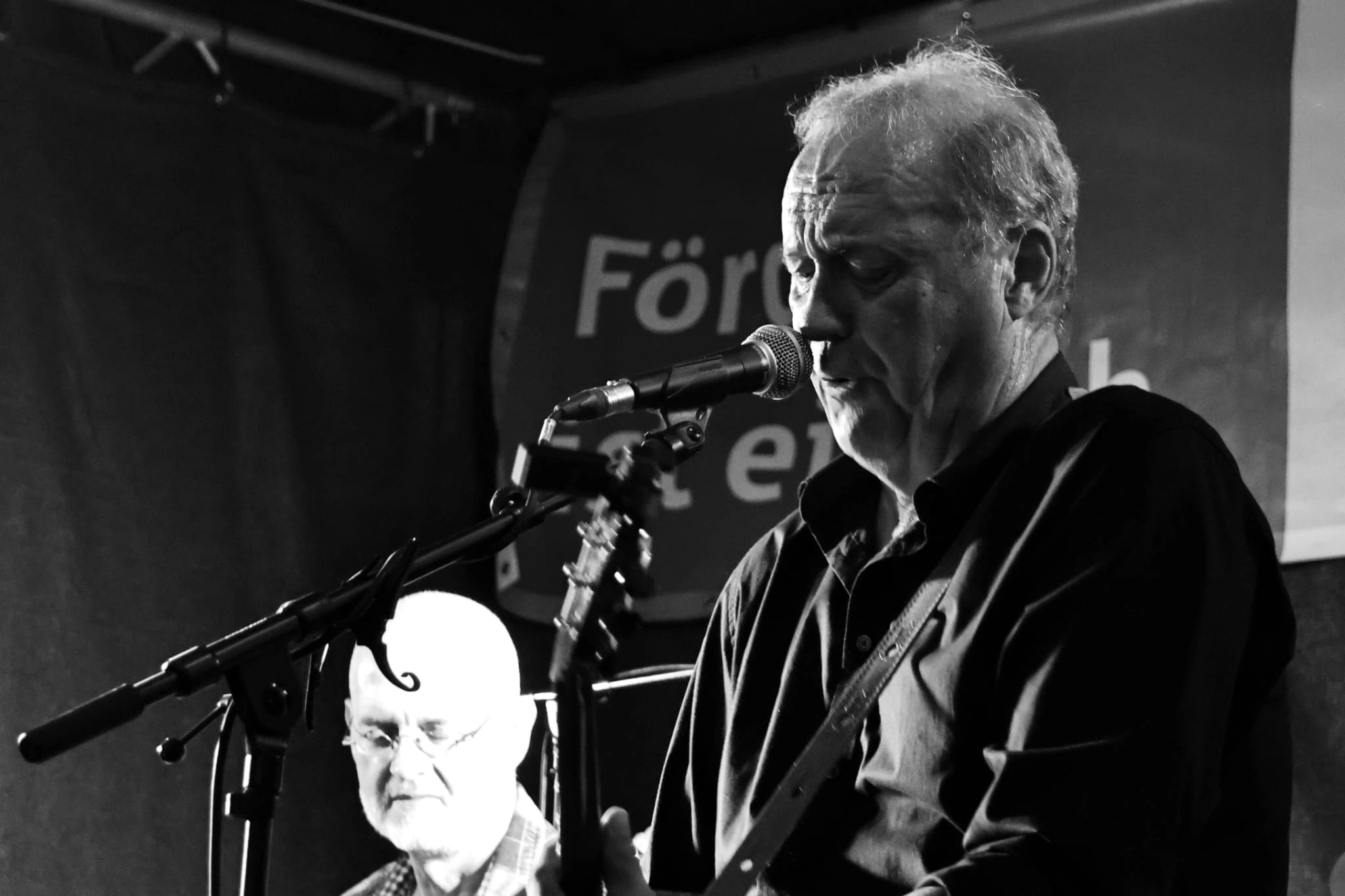 Peter Ernst singing into a microphone during a live performance